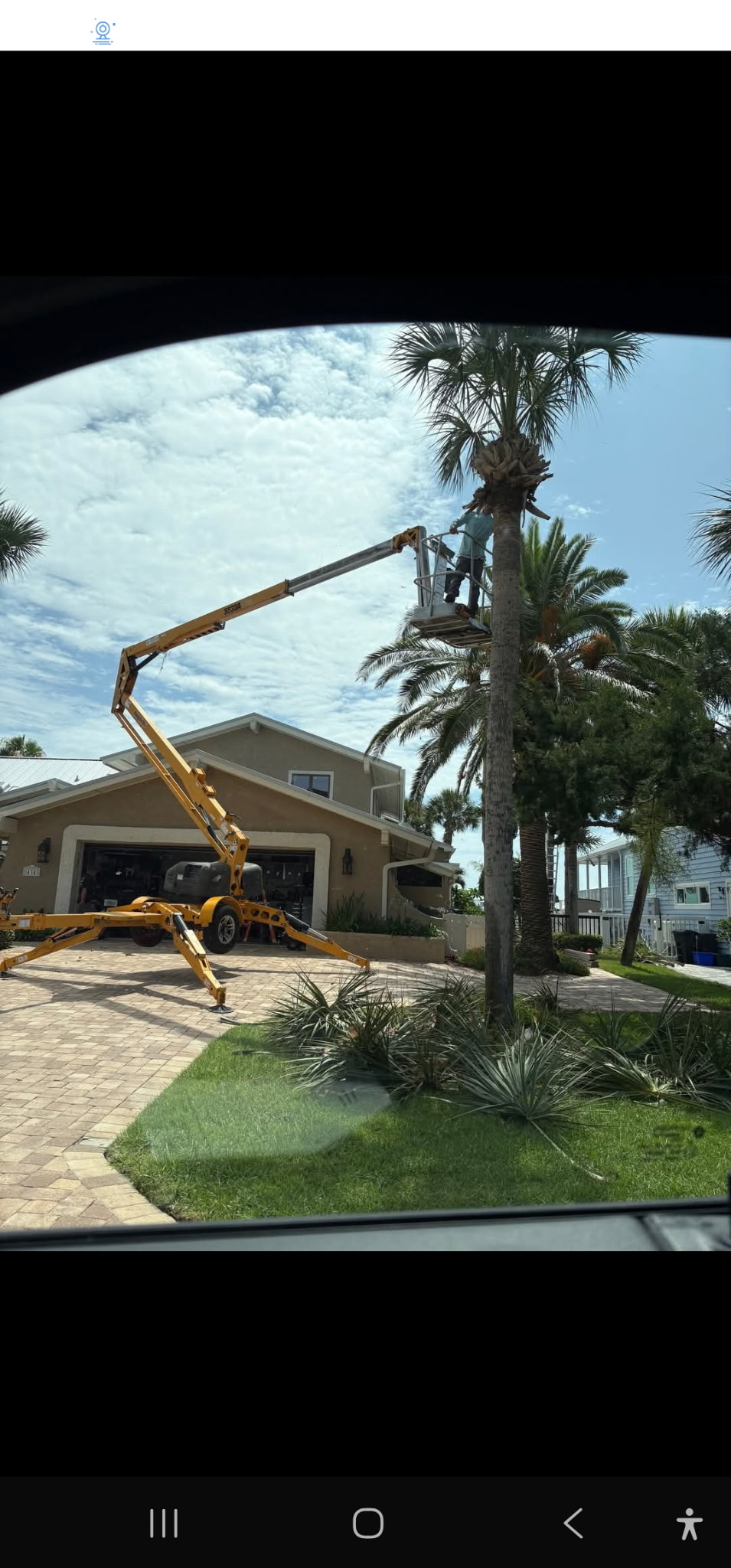 Aerial lift palm tree trimming at coastal home — Daytona Beach area FL